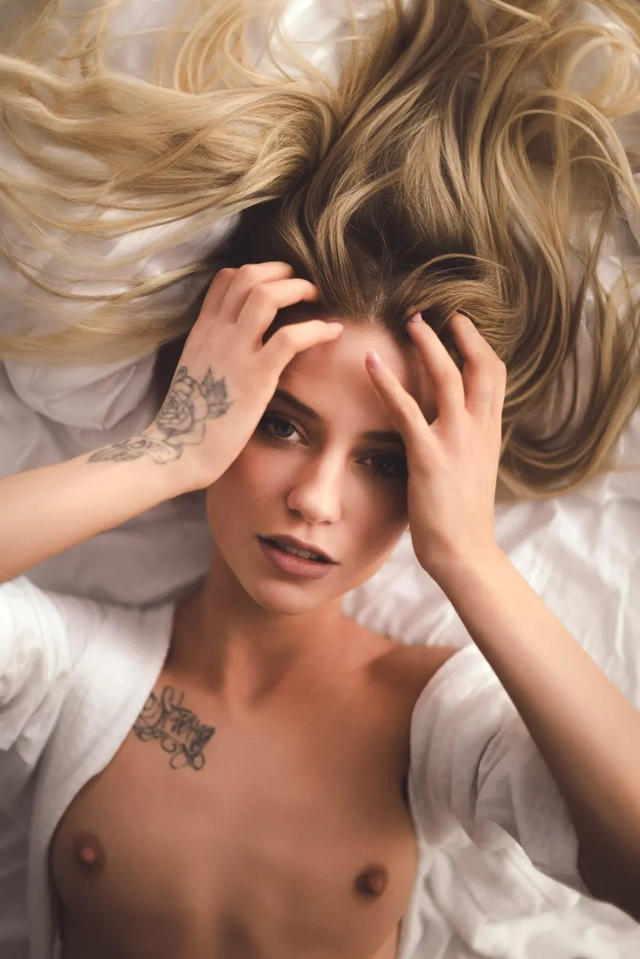 Sitting against the headboard, light catching her hair.